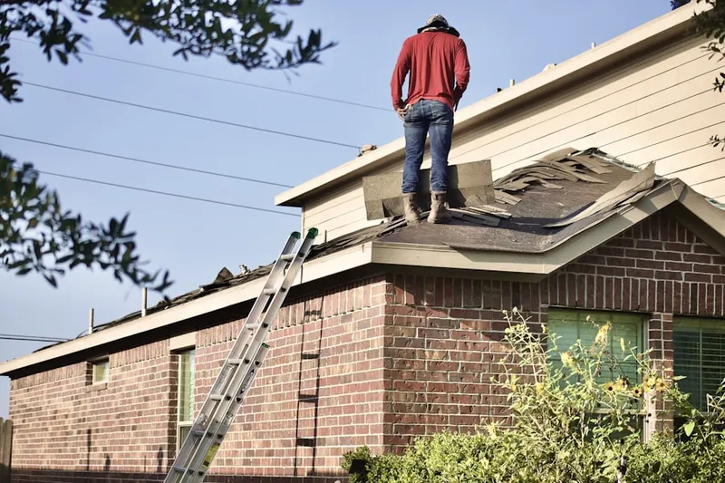 Professional roofer working on a residential roof in Honeyville